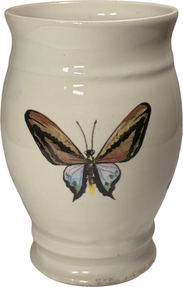 An off-white ceramic bud vase featuring a painted butterfly with brown, black, and blue wings on the front, isolated on a white background.